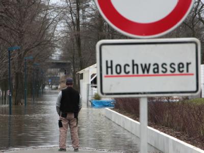Hochwasser-Warnschild auf einem Fußweg bei Magdeburg. Hochwasser