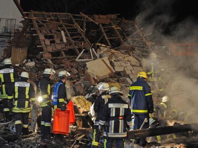 Rettungskräfte suchen in den Trümmern nach Opfern der Explosion. Trümmer