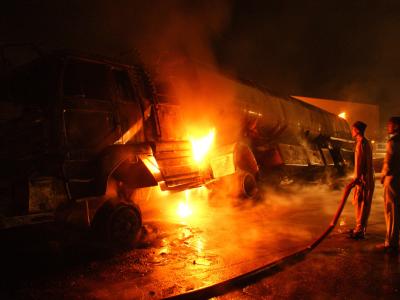 Flammen schlagen am Ort des Unglücks aus dem zerstörten Tankwagen. Unglücksort