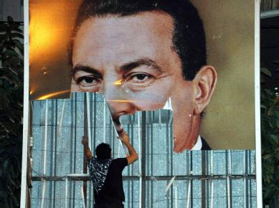 Ein Demonstrant reißt während einer Demonstration ein Poster Mubaraks herunter: Wird der Präsident dem Druck der Proteste im eigenen Land standhalten können? Proteste in Ägypten