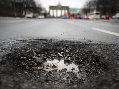 Schlagloch vor dem Brandenburger Tor: Im Bundestag streiten sich die Parteien über Handlungskonzepte. Schlaglöcher