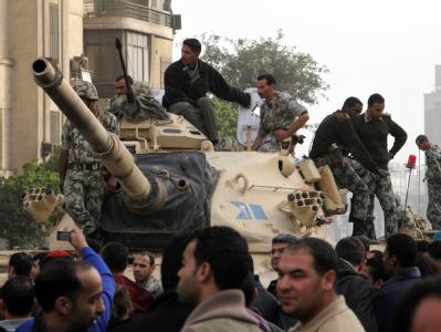 Zahlreiche Panzer haben sich in einer langen Kolonne auf dem Tahrir-Platz aufgestellt. An der Seite stehen gepanzerte Transporter. Panzer