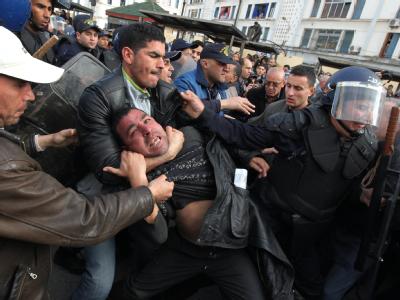 Gewalt in Algier: Polizisten zerren einen Demonstranten von der Straße. Gewalt in Algier