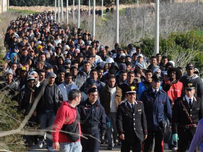 Tunesische Flüchtlinge werden in ein Auffanglager auf Lampedusa geführt. Tunesische Flüchtlinge auf Lampedusa