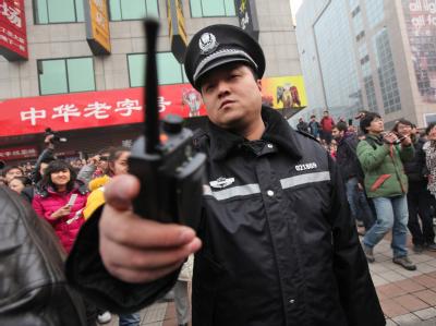 Ein chinesischer Polizist versucht Aufnahmen der Demonstration zu unterbinden. Polizei-Einsatz