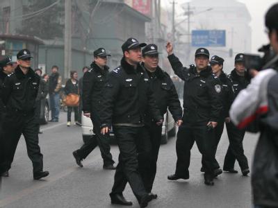 Chinesische Polizisten lösen in Peking eine Menschenmenge auf, nachdem es einen Online-Aufruf zu friedlichen Protestaktionen gegeben hatte. Chinesische Polizei