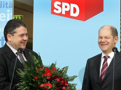 Mit einem Blumenstrauß wird der Wahlsieger der Bürgerschaftswahl in Hamburg, Olaf Scholz, in der Parteizentrale der SPD in Berlin vom Parteivorsitzenden Sigmar Gabriel (l) empfangen. Sigmar Gabriel und Olaf Scholz