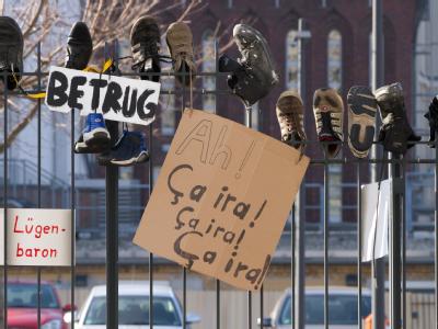Schuhe sind am Zaun des Bundesverteidigungsministeriums aufgespießt: Rund 450 Demonstranten hatten sich am Samstag zu der Aktion gegen Guttenberg verabredet, um «dem Lügenbaron den Schuh» zu zeigen. Demo in Berlin