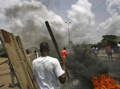 Demonstranten haben in Abidjan aus brennenden Autoreifen Straßensperren errichtet. Abidjan