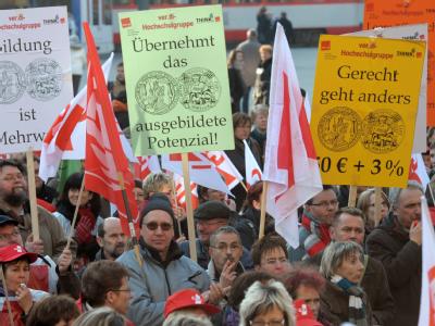 Mit Schildern und Fahnen stehen Streikende des öffentlichen Dienstes auf dem Marktplatz von Halle (Saale). Warnstreiks im öffentlichen Dienst