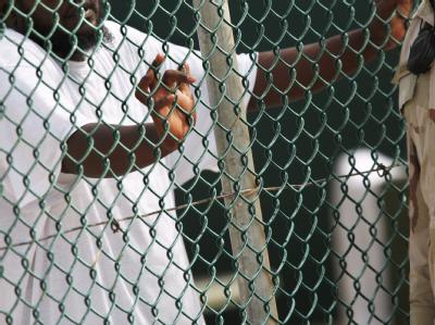 Ein Insasse (l) des US-Gefangenenlagers Guantanamo unterhält sich mit einem US-Soldaten. US-Präsident Obama hat grünes Licht für neue Militärverfahren in Guantanamo gegeben. US-Gefangenenlagers Guantanamo
