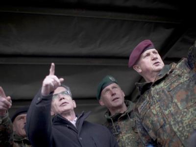 Verteidigungsminister Thomas de Maizière (CDU) steht im Gefechtsübungszentrum des Heeres in Letzlingen in Sachsen-Anhalt bei einer Vorführung zwischen Offizieren. (Archvbild) De Maizière besucht Heeressoldaten