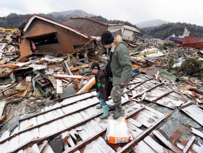 Eine Mutter geht mit ihrem Kind über die Trümmer, die der Tsunami hinterlassen hat. Trümmerwelt