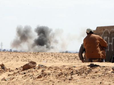 Libysche Rebellen gehen in Deckung vor Angriffen der Armee auf der Straße zwischen Adschabija und Benghasi. Detonation
