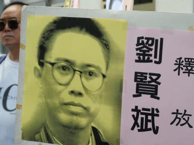 Ein Demonstrant einer Menschenrechtsgruppe hält bei einer Demonstration in Hongkong ein Poster des chinesischen Dissidenten Liu Xianbin. Dissident in China zu zehn Jahren Haft verurteilt