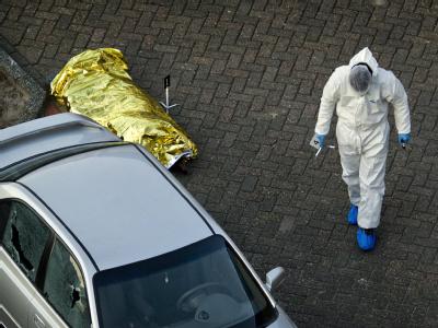 Eine abgedeckte Leiche liegt auf dem Parkplatz vor dem Einkaufszentrum: Sieben Tote, 17 Verletzte - und noch ist kein Motiv erkennbar. Amoklauf