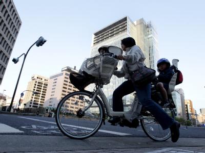 Eine japanische Mutter fährt mit ihrem Kind durch Tokio. Verunsichert
