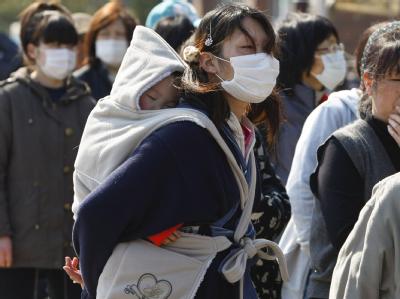 Eine Mutter steht mit ihrem Kind an, um im Hilfslager in der Stadt Onagawa Essen zu bekommen. Heimatlos