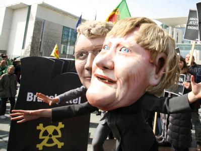Bundeskanzlerin Angela Merkel und Bundesumweltminister Norbert Röttgen aus Pappmarché: Atomkraftgegner machten am Freitag vor dem Kanzleramt in Berlin ihrem Ärger Luft. Demo gegen Atomenergie
