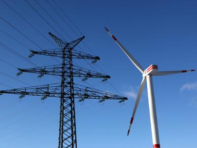 Anlage des Windkraftanlagenhersteller REpower neben einem Hochspannungsmast im schleswig-holsteinischen Brunsbüttel. Windkraftanlage vor Hochspannungsleitung