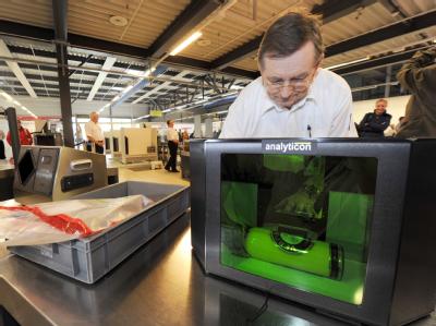 Ein Mitarbeiter der Bundespolizei demonstriert) auf dem Flughafen Schönefeld bei Berlin einen neuartigen Flüssigkeits-Scanner. Neue Sicherheitskontrollen an EU Flughäfen