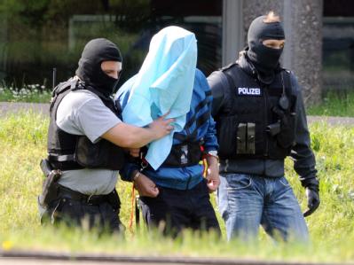 Ein mutmaßliches Al-Kaida Mitglied verlässt nach dem Haftprüfungstermin den Bundesgerichtshof. Vermummt