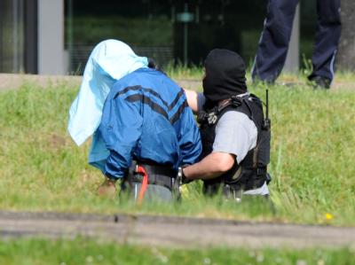Einer der drei mutmaßlichen Terrorverdächtigen wird auf dem Gelände des Bundesgerichtshofes von Polizeibeamten geführt. Mutmaßliche Terroristen werden beim BGH vorgeführt
