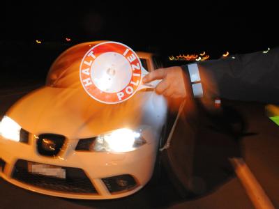 Ein Polizist hält in Friedrichshafen ein Fahrzeug an. Die Polizei hat in der ganzen Nacht zum Sonntag im Bodenseekreis Fahrzeugkontrollen durchgeführt. Polizeikontrolle in Friedrichshafen