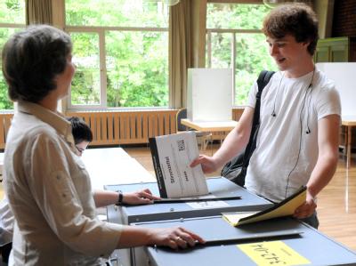 Der Schüler Julian Burmester wirft seine beiden Stimmzettelhefte zur Bürgerschaftswahl in Bremen in zwei entsprechend gekennzeichnete Wahlurnen. Sein erstes Mal