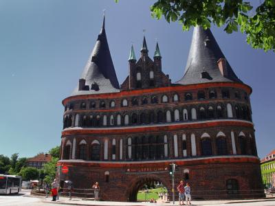 Passanten laufen am Holstentor in Lübeck vorbei. 17 Patienten haben sich möglicherweise in einem Restaurant in der Hansestadt infiziert. Lübeck