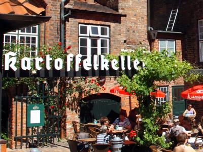 Gäste sitzen im Garten des Restaurants Restaurant 'Kartoffelkeller'