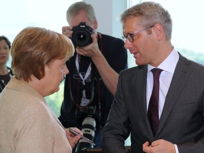 Bundeskanzlerin Angela Merkel und Bundesumweltminister Norbert Röttgen unterhalten sich zu Beginn der Sitzung des Bundeskabinetts im Kanzleramt. Merkel und Röttgen