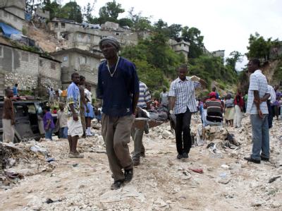 Einwohner tragen eine Leiche weg: In Haiti starben bereits 23 Menschen nach Dauerregen, Vorboten der Hurrikansaison in der Westkaribik. Leichenbergung