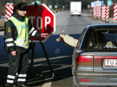 An der deutsch-dänischen Grenze bei Padborg/Froeslev kontrolliert am 10.12.2002 ein dänischer Grenzpolizist die Papiere eines einreisenden Autofahrers. Grenzkontrolle