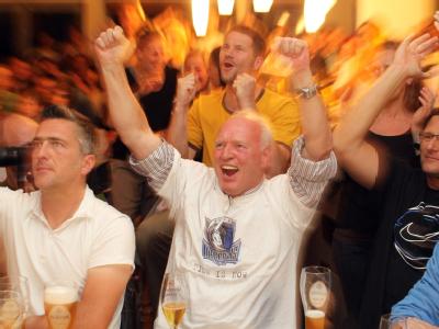 Der Vater von Dirk Nowitzki, Jörg Nowitzki (M.), jubelt in einem Lokal in Würzburg während einer Live-Übertragung des Finalspiels zwischen Miami Heat und Dallas Mavericks. Vater Nowitzki in Würzburg