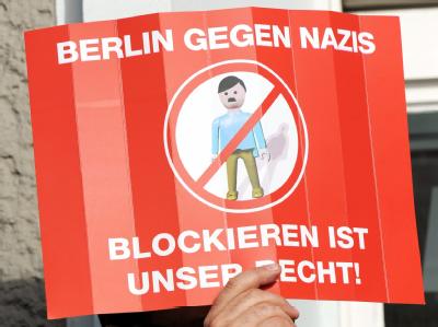Ein Demonstrant hält in Berlin bei einer Gegendemonstration zu einer NPD-Kundgebung ein Protestplakat. NPD-Aufmarsch