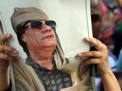 Demo in Tripolis: Ein Unterstützer vom Muammar al-Gaddafi hält sein Porträt in die Luft. Gaddafi warnt Europa