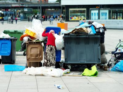 Frauen durchsuchen auf dem Alexanderplatz in Berlin Mülltonnen nach Pfandflaschen und anderem Nützlichen. Foto: Maurizio Gambarini/ Archiv Armut in Deutschland