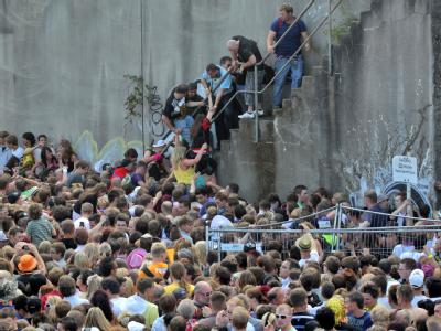 Kurz vor dem Unglück bei der Loveparade stehen Menschen dicht gedrängt an einem Tunnelausgang in Duisburg. Bei dem Techno-Event vor etwa einem Jahr waren 21 Menschen gestorben. Loveparade