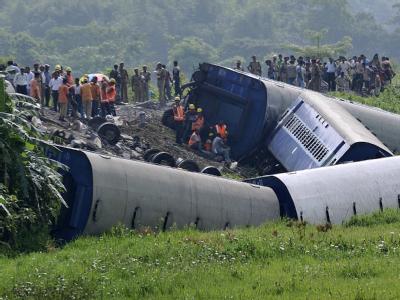 Rettungskräfte inspizieren das Zugwrack in Assam. Zug verunglückt