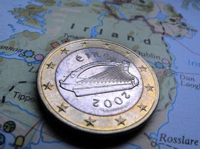 Eine irische Ein-Euro-Münze liegt auf einer Karte von Irland. Irischer Euro