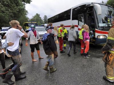 Überlebende des Massakers werden per Bus nach Hause gebracht. Überlebende