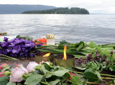 Kerzen und Blumen zum Gedenken an die Opfer. Im Hintergrund die Insel Utøya - Schauplatz des Massakers. Kerzen und Blumen