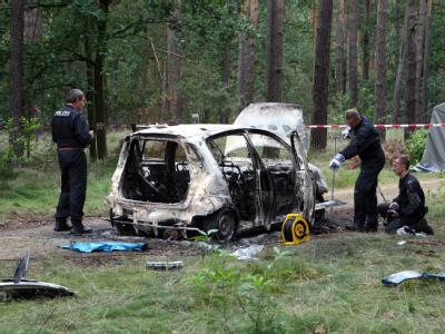 Die Polizei sichert in einem abgesperrten Waldstück bei Börnicke (Havelland) den Fundort. Zwei tote Kinder sind in einem ausgebrannten Auto gefunden worden. Kinderleichen in ausgebranntem Auto