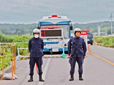 Polizisten bewachen eine Durchgangsstation zum Sperrgebiet um das AKW Fukushima. Bewachtes Sperrgebiet