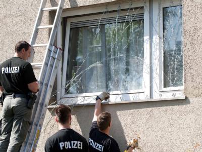 Polizeibeamte entfernen den Stacheldraht vom Fenster. Was hatte der mutmaßliche Entführer in der Wohnung vor? Spurensicherung