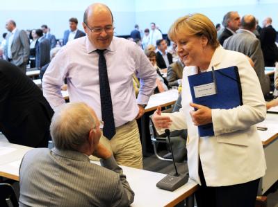 Kanzlerin Merkel spricht zu Beginn der Fraktionssondersitzung mit Bundesfinanzminister Schäuble und dem parlamentarischen Staatssekretär im Finanzministerium, Steffen Kampeter (l). CDU/CSU-Bundestagsfraktion berät über Euro-Krise