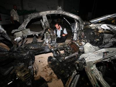 Ein Palästinenser untersucht die Trümmer eines durch einen israelischen Luftschlag zerstörten Wagens. Zerstörtes Auto