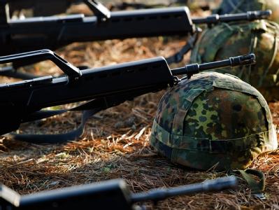 Bundeswehrhelme und Gewehre vom Typ Heckler & Koch G36 liegen während einer Schießübung auf einem Truppenübungsplatz. Deutsche G36-Sturmgewehre