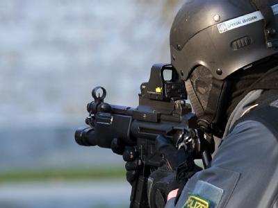 Ein Beamter eines Spezialeinsatzkommandos (SEK) sichert während einer Übung mit der Waffe im Anschlag einen Zugriff. (Symbolbild) Polizist im Dienst